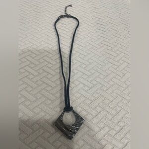 Black cord necklace with dark gray pendant